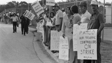 Air traffic controllers picket near a fence at DFW Airport's FAA tower during the PATCO strike. Aug. 5, 1981. (Fort Worth Star-Telegram Collection)