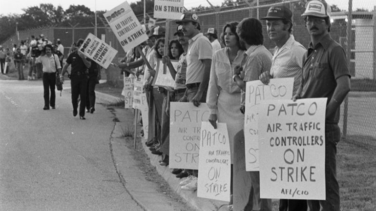 Air traffic controllers picket near a fence at DFW Airport's FAA tower during the PATCO strike. Aug. 5, 1981. (Fort Worth Star-Telegram Collection)